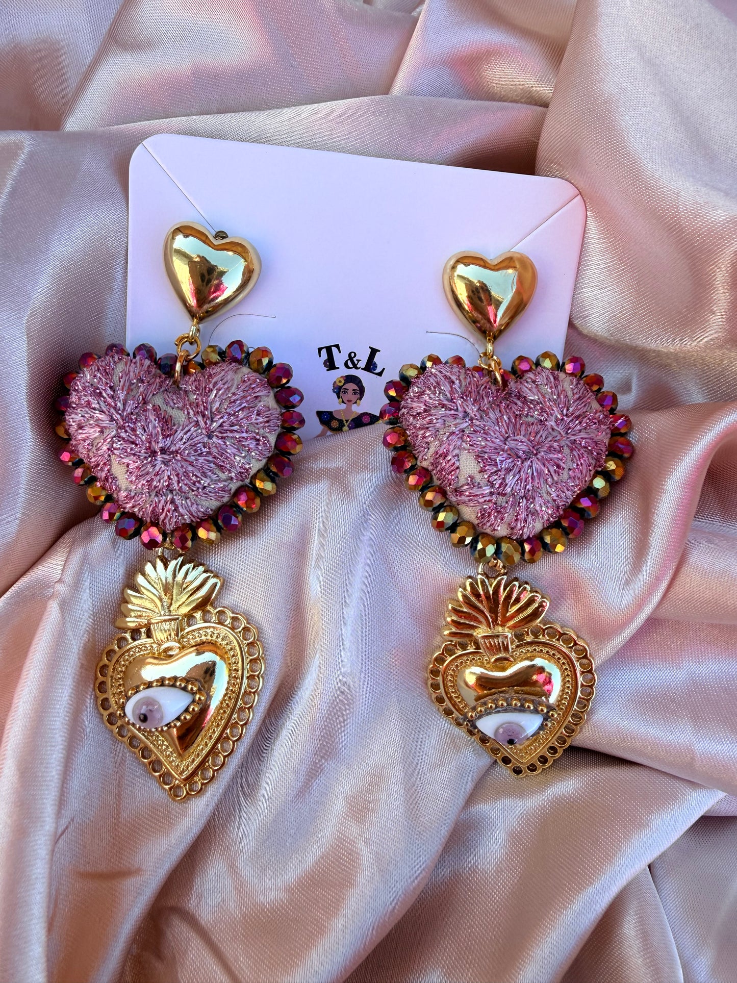 Aretes Bordados a Mano Corazón Rosa con Hilos Metálicos y Sagrado Corazón de Acero /Ojo Protector