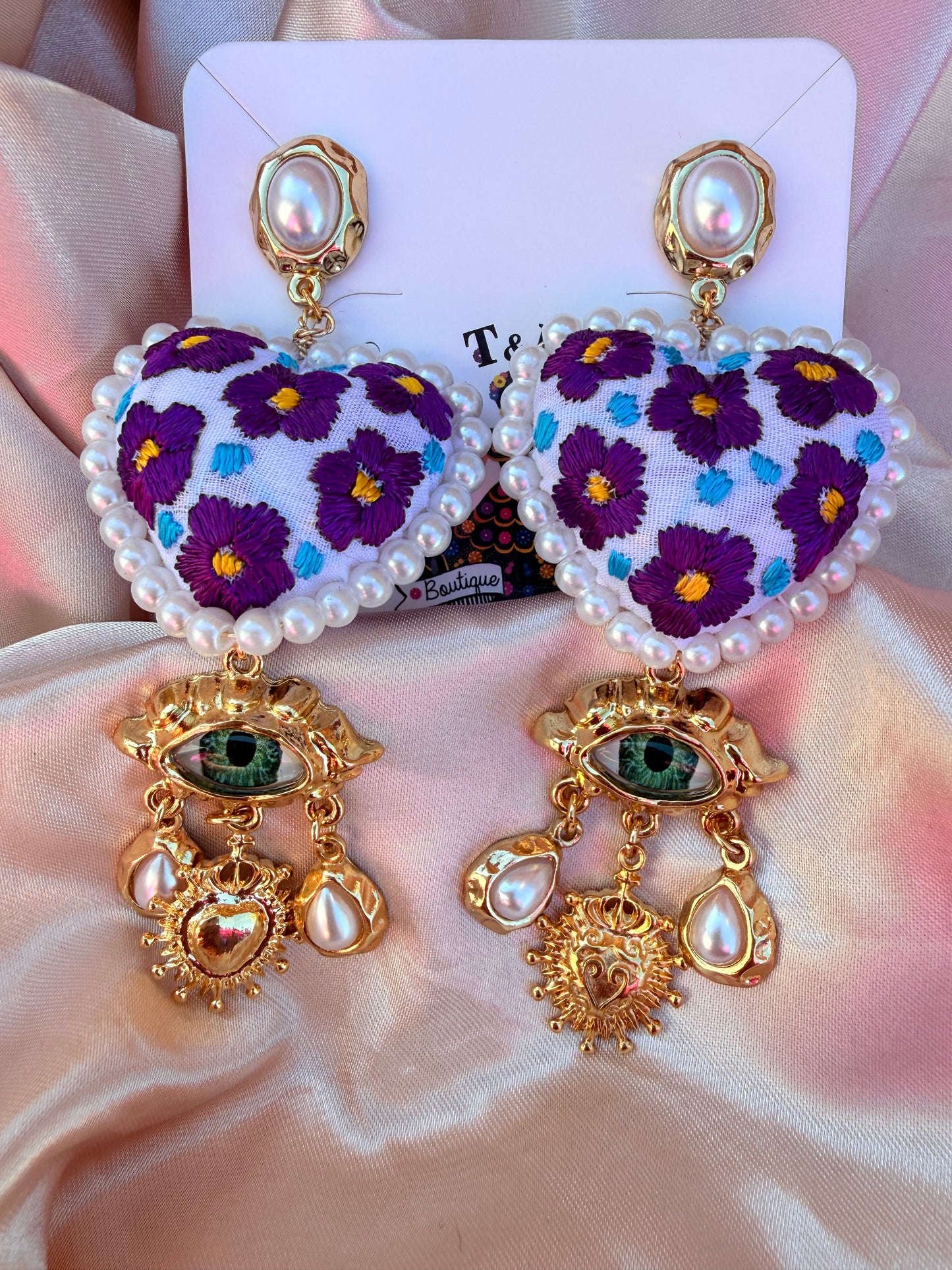 Aretes Bordados a Mano con Ojo Protector y Dije de Sagrado Corazón – Ligeros y Únicos
/handmade jewelry/morados