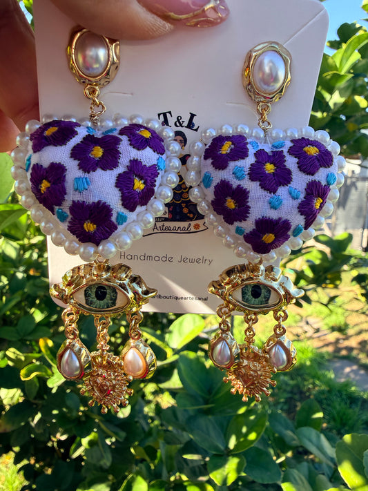 Aretes Bordados a Mano con Ojo Protector y Dije de Sagrado Corazón – Ligeros y Únicos
/handmade jewelry/morados