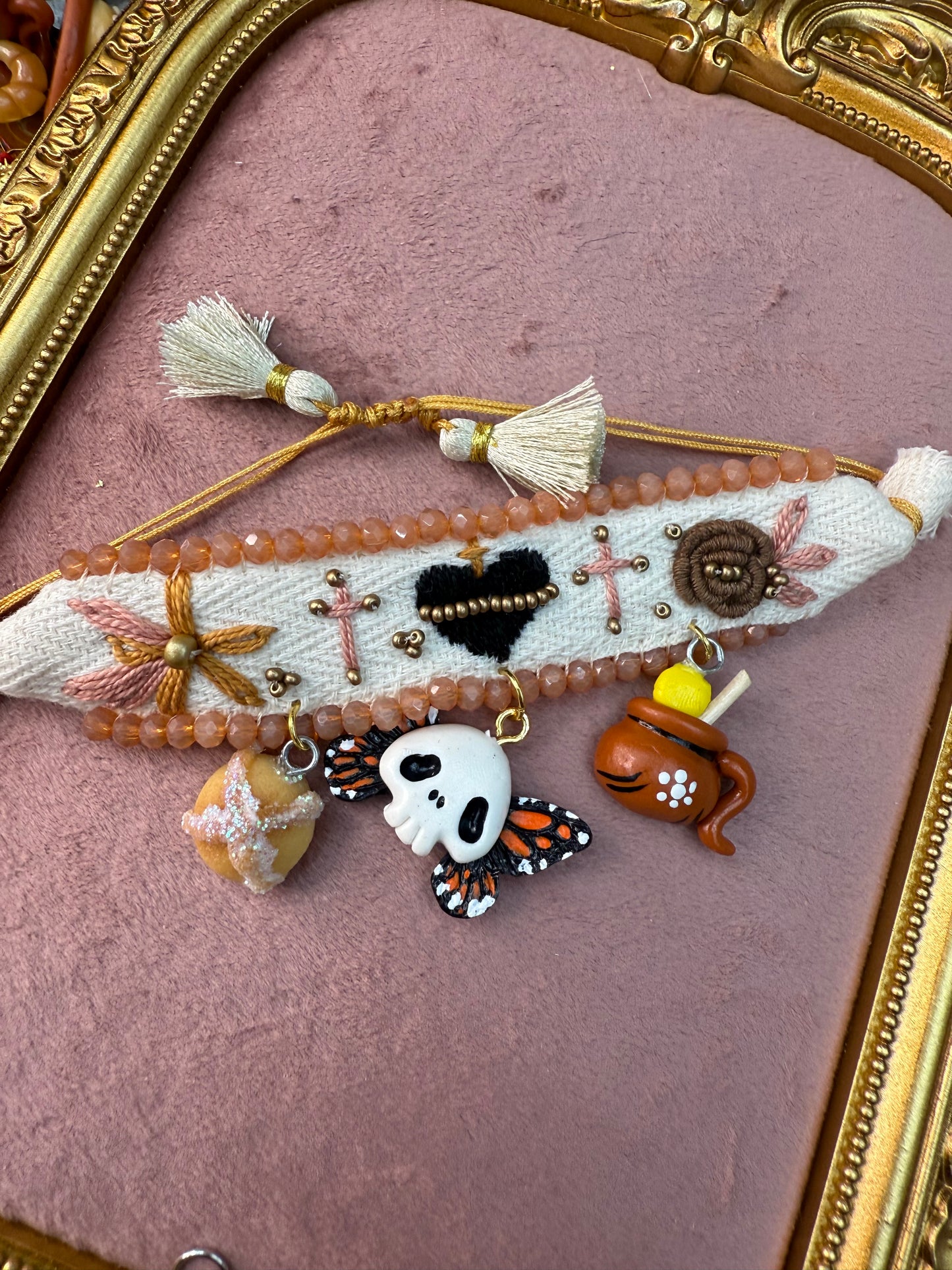 Pulceras bordadas/con dijes de  dia de muertos